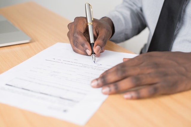 Person using a silver pen to sign a contract